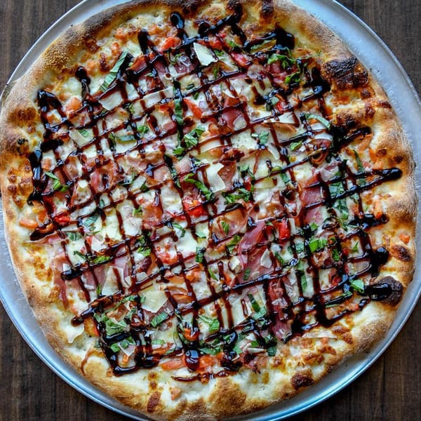 Buccieri's Pizzeria pizza with prosciutto, tomatoes, basil, cheese, and balsamic glaze.